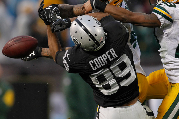 Oakland Raiders Amari Cooper (89) cannot hold onto the ball as he is defended by the Green Bay Packers Morgan Burnett (42), and Casey Hayward (29) in the fourth quarter of their NFL game at O.co Coliseum in Oakland, Calif, on Sunday, Dec. 20, 2015. (Aric Crabb/Bay Area News Group)