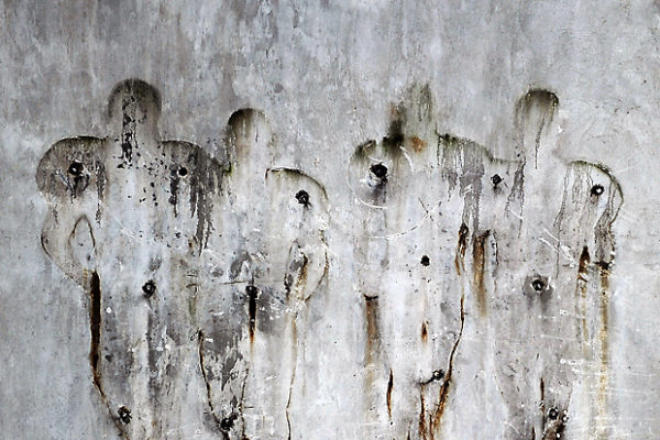 The outlines of football players mark the wall behind the Paterno statue after the signs, figures, and words on the walls were removed as well.