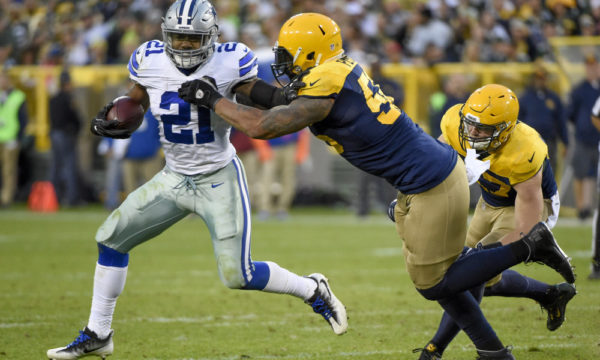 Oct 16, 2016; Green Bay, WI, USA; Dallas Cowboys running back Ezekiel Elliott (21) carries the ball as Green Bay Packers linebacker Julius Peppers (56) defends in the fourth quarter at Lambeau Field. Mandatory Credit: Benny Sieu-USA TODAY Sports